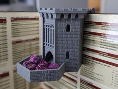 there is a small castle with purple bags in the box next to it on display