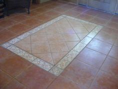 a kitchen floor with a tile design on the bottom and an area rug in the middle