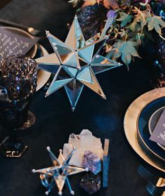 the table is set with blue and silver plates, napkins, and star decorations