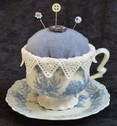 a tea cup and saucer with some buttons on the top in front of a black background