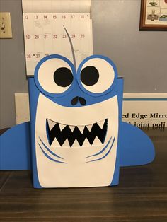 a blue and white box shaped like a cartoon character with big eyes, sharp teeth