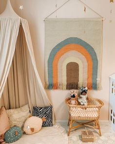 a child's bedroom with a rainbow rug hanging above the bed and toys on the floor