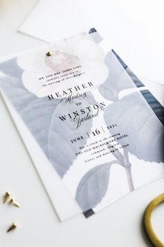 the wedding stationery is laid out next to some scissors