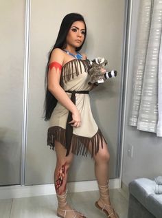 a woman dressed in native american clothing posing for the camera