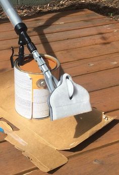 a bucket with a mop on top of it sitting on a wooden floor next to a cardboard box