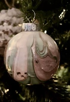 a glass ornament hanging from a christmas tree