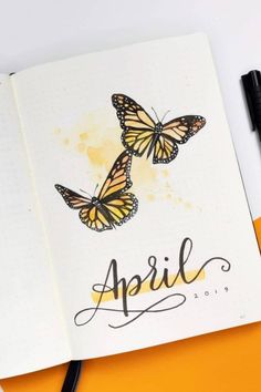 an open notebook with two butterflies on it and the words april written in black ink