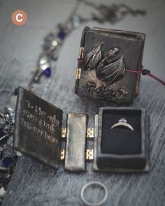 an assortment of jewelry on a table with rings and necklaces attached to the box