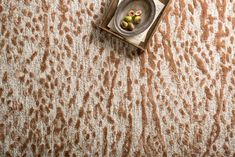 an animal print rug with a small plate on the floor next to it and two olives