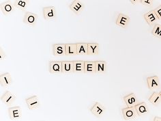 scrabble tiles spelling out the word slay queen on a white surface surrounded by words