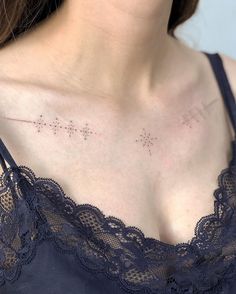 a close up of a woman's chest with small stars on the top of it