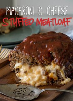 a meatloaf covered in cheese and sauce on a cutting board with a fork