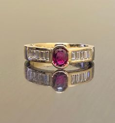 DeKara Designs Collection Metal- 18K Yellow Gold, .750. Stones- 1 Genuine Oval Ruby 0.60- 0.65 Carats. 8 Asscher Cut Diamonds F-G Color VS2 Clarity, 0.40 Carats. Size- 4-12. FREE SIZING Art Deco Inspired Oval Ruby Asscher Cut Diamond Engagement Ring Handmade in 18K Yellow Gold. The ring features an amazingly fiery oval ruby that is bezel set in the center. The sides of the ring has four amazing asscher cut diamonds that are all professionally channel set. The yellow gold is very rich and complim Yellow Gold Ruby Ring With Channel Set Diamonds, Ruby Ring With Channel Set Diamonds In Yellow Gold, Ruby Ring With Diamond Channel Set For Wedding, Ruby Ring With Vvs Clarity And Baguette Cut, Baguette Cut Ruby Ring With Vvs Clarity, Luxury Baguette-cut Ruby Ring In Yellow Gold, Classic Ruby Rings With Baguette Cut, Yellow Gold Wedding Ring With 17 Jewels, Yellow Gold Ruby Ring With Channel Setting For Anniversary