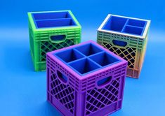 three different colored plastic containers sitting next to each other on a blue surface with one empty container in the middle