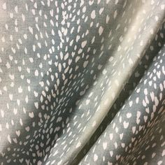 a close up shot of the fabric with white hearts on it and grey background,