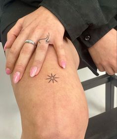 a woman's legs with tattoos on them and her hand resting on the knee