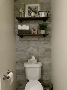 a small bathroom with a toilet and shelves above the toilet bowl, along with other items