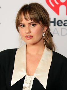 a close up of a person wearing a black and white shirt with an open collar