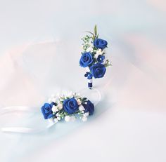 two bridal bouquets with blue roses and baby's breath flowers on them