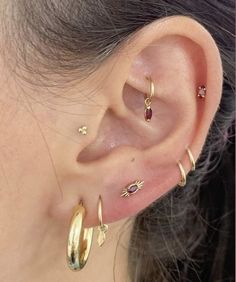 a close up of a person's ear with three different types of piercings