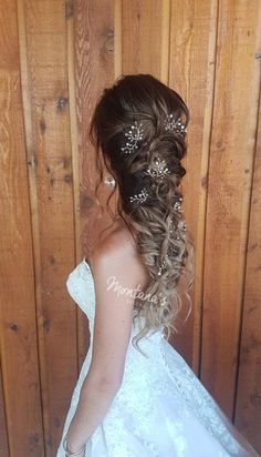 a woman in a wedding dress with long hair and pearls on her head is standing against a wooden wall