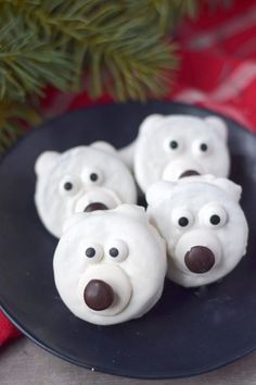 some white frosted polar bears are on a black plate next to a pine tree