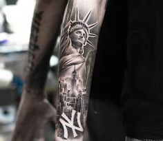 a man's arm with a statue of liberty tattoo on it