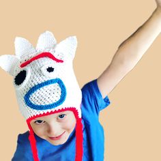 a little boy wearing a crocheted hat with a cow on it's head