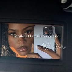 a woman taking a selfie with her cell phone in the back seat of a car