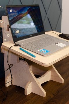 a laptop computer sitting on top of a wooden stand