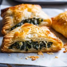 two pastries with spinach and cheese on top