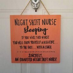 an orange sign hanging on the side of a door saying, night shift nurse sleeping