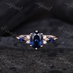 a blue sapphire and diamond ring sitting on top of a piece of wood