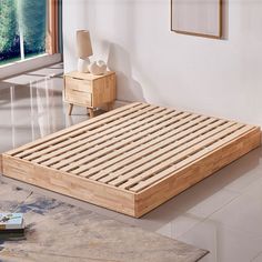 a bed with wooden slats on top of it in a room next to a window