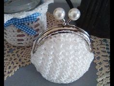 a white purse sitting on top of a doily next to a jar filled with pearls