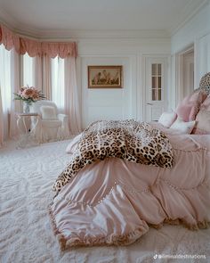 a leopard print comforter on a bed in a white room with pink curtains and pillows