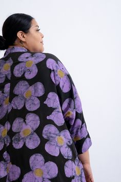 A loose-fitting dress made of rayon, featuring a mandarin collar and a button front. The Para has batwing sleeves, inseam pockets, and a slightly curved hem. Our soft LENZING™ ECOVERO™ rayon provides a relaxed drape, but the Para still has enough volume to create bold shapes in movement. Love Perfect is a whimsical print with graphic and playful purple daisies, each with a dark yellow center, dancing on a black background. Irene is 5'9" and wears a size 2X (pictured wearing white sneakers) Julee Purple Accessories With Black Dress, Osei Duro, Purple Daisy, Fitting Dress, Loose Fitting Dresses, Dark Yellow, Ethical Clothing, Dyed Dress, Mid Dresses