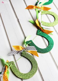 the letters g are made out of glittered horseshoes and green paper streamers