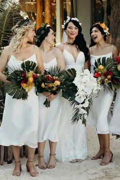 the bridesmaids are all wearing white dresses and holding bouquets in their hands