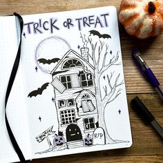 a halloween themed notebook with the words trick or treat written on it next to a pumpkin