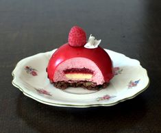 a piece of cake on a plate with raspberries and cream in the middle