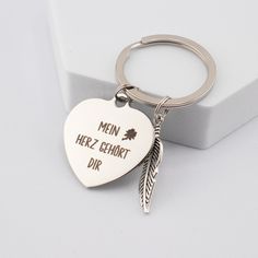 a heart shaped keychain with the words men herz ehort dir on it