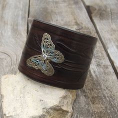 "Made from top quality Italian vegetable tanned leather. Hand dyed and embossed with bronze butterfly. Cuff is 2\" (5 cm) wide Please measure carefully your wrist and select the most preferable size! If you need a diferent size, please let me know after purchase in \"note for seller\". Please visit to my another shop: https://www.etsy.com/shop/JeansBelt?ref=hdr_shop_menu FEDEX to USA and Australia! If you need a faster shipping please use this service. The delivery time will be up to 2 business Vintage Brown Engraved Cuff Bracelet, Vintage Hand Tooled Cuff Bracelet For Festivals, Vintage Hand-tooled Cuff Bracelet For Festivals, Brown Engraved Leather Cuff Bracelet, Brown Stamped Bohemian Cuff Bracelet, Bohemian Stamped Brown Cuff Bracelet, Adjustable Brown Cuff Bracelet With Patina, Brown Leather Engraved Cuff Bracelet, Bohemian Brown Cuff Bracelet With Patina