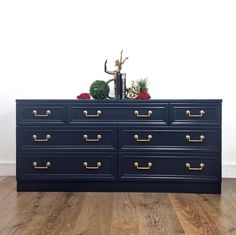 a black dresser with gold handles and drawers