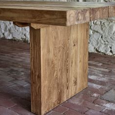 a wooden bench sitting on top of a brick floor