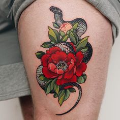 a snake and flower tattoo on the thigh