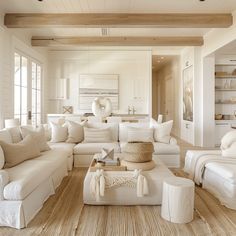 a living room filled with white furniture and lots of windows