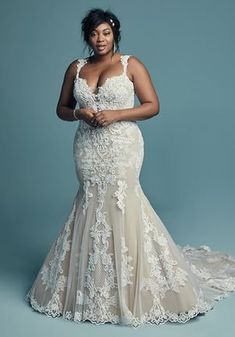 a woman in a wedding dress posing for the camera with her hands on her hips