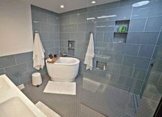 a bath room with a tub a sink and towels