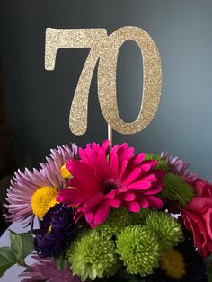 a bouquet of flowers with the number seventy on top